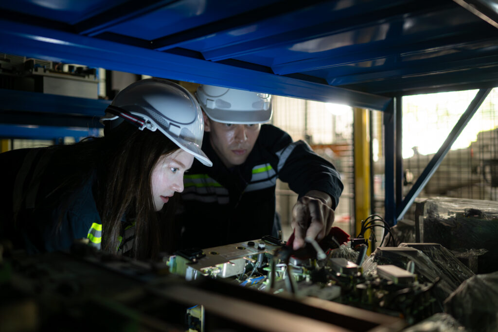 A young female engineer and a male supervisor work together in robotic arm spare parts warehouse, Robotic arm industry and engineering concept.